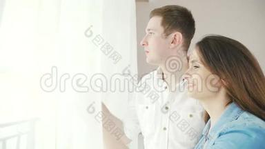 一对幸<strong>福</strong>而相爱的夫妇正站在窗边，<strong>挂</strong>着窗帘。