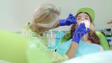 在现代牙科诊所与病人合作的医生。 女牙医