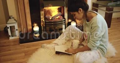 可爱的少女正在壁炉旁看书。 红色史诗。 4k.