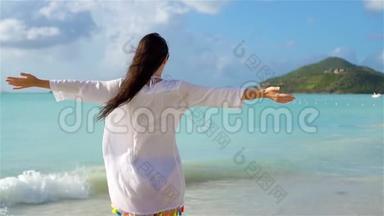 在热带海滨玩得很开心的年轻美女。 在海滨戴帽子的女孩的后景。 流动人口