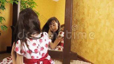 那个女孩正在镜子旁梳头。 小女孩正在梳头.. 那孩子正坐在镜子旁..