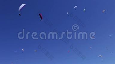 晴朗的一天，成群的<strong>滑翔伞</strong>在蓝天上翱翔