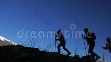 女人在山上行走在大自然中。 剪影。 女孩和孩子使用跋涉棒和北欧杆