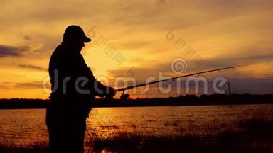 <strong>剪影</strong>渔夫在背景黄昏日落时在河中投掷鱼竿。 <strong>钓鱼</strong>时傍晚美丽的日落
