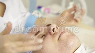 美丽的女人在水疗沙龙接受美容治疗。 美容医生戴着医用手套，摸着女孩`脸。
