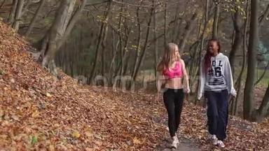两位多元<strong>文化</strong>的<strong>体育</strong>女朋友正在秋天公园散步。