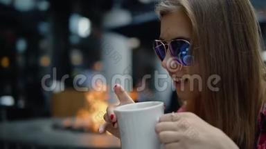 30多岁的女孩戴着<strong>名牌</strong>眼镜在城市街头咖啡馆喝茶