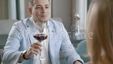 男人在时尚的灯光下，喝着<strong>一杯红酒</strong>，说着祝酒词。