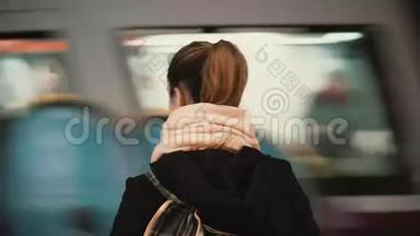 年轻女子站在地铁站台上，背景是<strong>经过火车</strong>。 等待地铁上班的女孩。