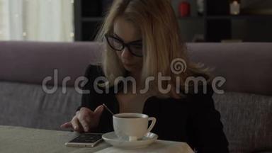 美女在背景咖啡杯上的屏幕<strong>手机</strong>上<strong>输入</strong>信息