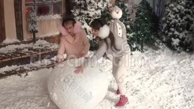 圣诞节或新年。 孩子们<strong>堆雪人</strong>。 两个小女孩做一团雪