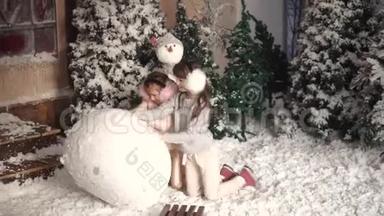 圣诞节或新年。 孩子们堆雪人。 两个小女孩做一团雪