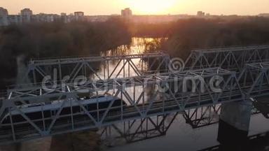 从日落时火车经过的铁路桥的高度观看