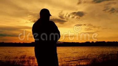 <strong>剪影</strong>渔夫在背景黄昏日落时在河中投掷鱼竿。 <strong>钓鱼</strong>时傍晚美丽的日落
