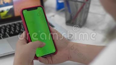 女人用智能手机看手机上的绿色屏幕，