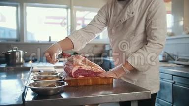 屠夫将香料加入到一大块新鲜的生肉中，<strong>放在</strong>商业厨房的<strong>木板上</strong>，动作缓慢