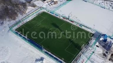 业余足球场的空中射击。 在冬天拍摄一个白色布局的现代足球场。 4k个镜头
