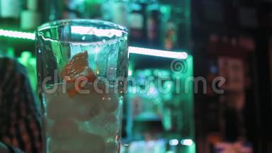 关闭<strong>酒吧</strong>玻璃和调酒师在<strong>酒吧</strong>柜台上的绿色灯光背景。