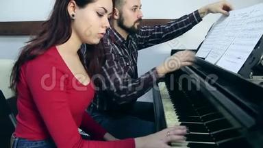 男教师，女学生在音乐<strong>学校</strong>弹<strong>钢琴</strong>