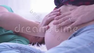 怀孕夫妇抚摸怀孕的肚子。 爸爸妈妈把手放在怀孕的肚子上。 生育观念。 怀孕。 快乐