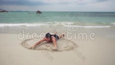 年轻人在海滨潮湿的沙滩上画了一个心脏符号。 慢动作。 1920x1080