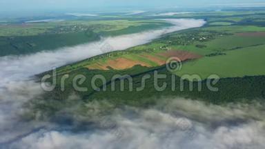 在云层上方的山上鸟瞰田野，日出时鸟瞰河流上空的雾，浓雾笼罩河流