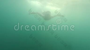日落时分，年轻美丽的棕色头发的女人带着游泳面具在水下潜水，在<strong>海水</strong>在<strong>海水</strong>中游泳