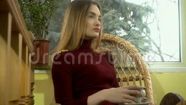 年轻的女孩，<strong>化妆</strong>漂亮，坐在家里的柳条<strong>椅子</strong>上，喝着芳香的咖啡，冬天和冬天。