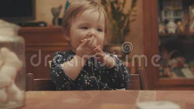 小宝宝坐在桌子旁边吃饼干