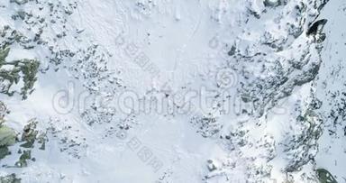 空中俯瞰冬季雪山，登山滑雪者向上攀登。雪覆盖