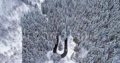 在山冬白雪覆盖的森林里，在簪弯转弯的道路上向前俯视汽车。 白<strong>松松</strong>松