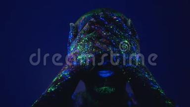 一个人在紫外线下从脸上擦荧光粉。 在生活环境前的空虚。