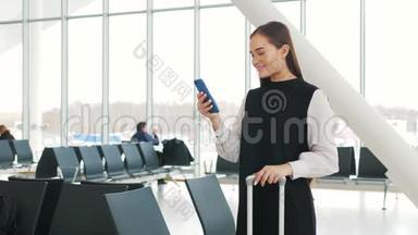 戴着笔记本电脑、手机和行李坐在机场微笑的亚洲女商人的侧面肖像。 终点站铁路