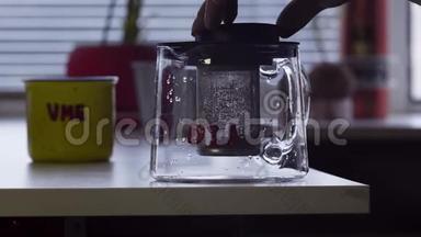 相机显示桌子上有<strong>大杯子</strong>和玻璃茶壶放在厨房的桌子上。
