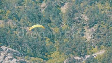 黄色滑翔伞在绿油油的克里米亚山脉背景下飞翔