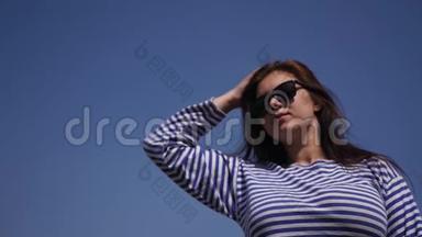欣赏一个年轻漂亮的女孩穿着条纹衬衫，大自然和蓝天。 慢动作。 1920x1080。 <strong>高清高清</strong>