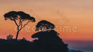 时间流逝，美丽的夕阳落在意大利索伦托的意大利山上的树木后面