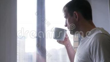 一个年轻开朗的人喝白杯子、茶或咖啡。 4K，3840x2160。 <strong>高清高清</strong>