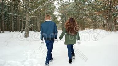 冬天的散步，美丽的男人和女孩走在雪地的路上，穿过树林，这对幸福的情侣相爱了