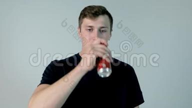 喝汽水的年轻人。 穿着黑色衬衫的年轻人喝着苏打水，白色背景