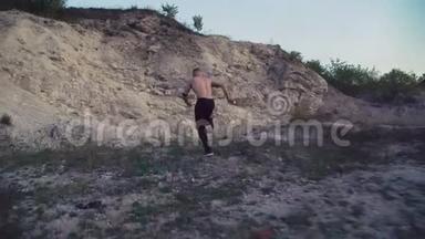 强<strong>壮</strong>的<strong>男人</strong>在粗糙的岩石上慢跑，训练自由战斗。 4K