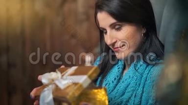 微笑的黑发女人打开圣诞树灯的礼盒