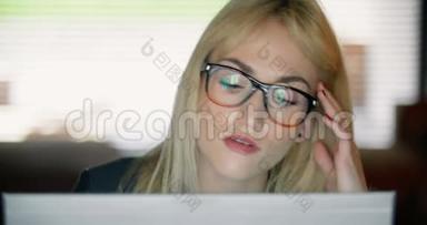 一个非常疲惫的年轻女人<strong>深夜</strong>在电脑上<strong>工作</strong>。