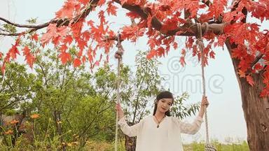 <strong>亚洲</strong>美丽的越南女孩，<strong>长发</strong>在秋季花园的秋千上。