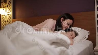 醒来的女人在床上笑着，妈妈来到熟睡的孩子<strong>身边</strong>