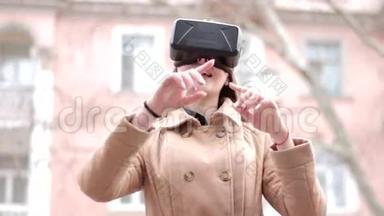 年轻快乐的女人，戴着网络虚拟现实vr耳机眼镜，穿着米色外套，在外面的街道上玩得很开心