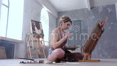 女艺术家坐在地板上<strong>画画</strong>画室里的画