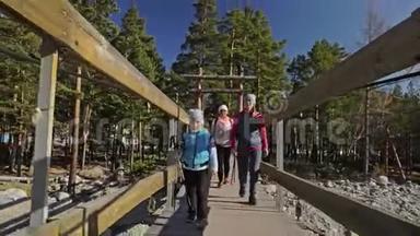 女人在大自然中行走北欧。 女孩和孩子使用跋涉棒和北欧杆，背包。 人们在散步