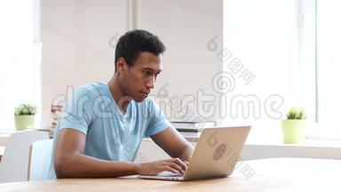 悲伤的黑人因<strong>失去</strong>而心烦意乱，在笔记本电脑上<strong>工作</strong>