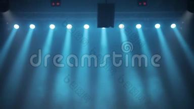 长镜头的场景，舞台灯光用彩色聚光灯和烟雾。 烟雾中的蓝色聚光灯照耀着舞台。